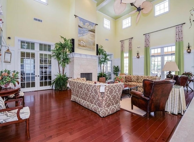 living room featuring french doors, a healthy amount of sunlight, and a high ceiling