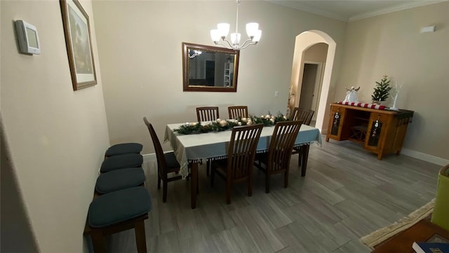 dining room featuring a notable chandelier, wood-type flooring, and ornamental molding