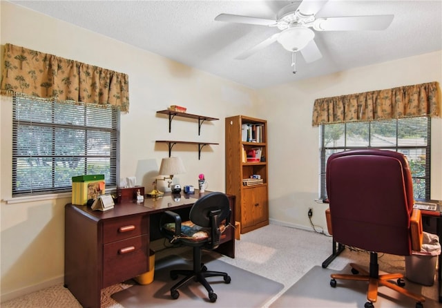 carpeted home office featuring a textured ceiling and ceiling fan