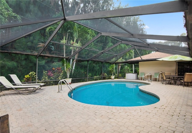 view of swimming pool featuring a lanai and a patio