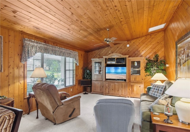 carpeted living room with lofted ceiling with skylight, wooden walls, ceiling fan, and wooden ceiling