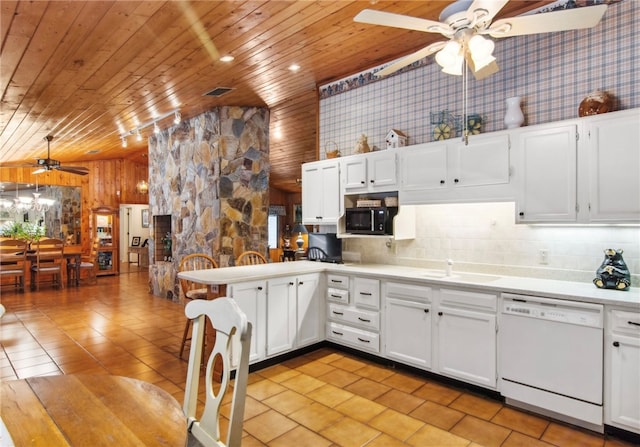 kitchen featuring white cabinetry, wooden walls, sink, dishwasher, and ceiling fan