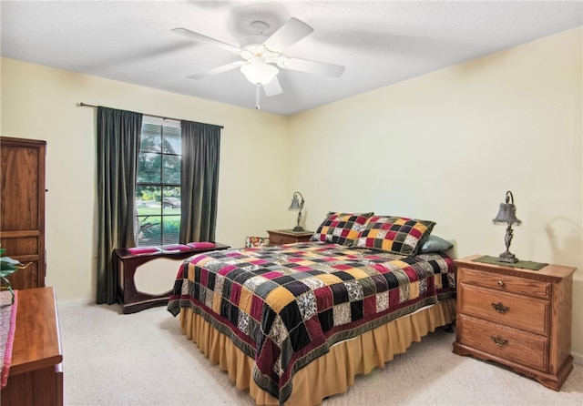 carpeted bedroom featuring ceiling fan and a textured ceiling