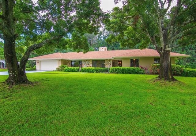 ranch-style home featuring a garage and a front lawn