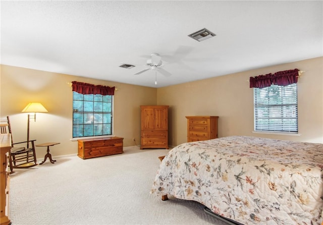 bedroom with ceiling fan, multiple windows, and carpet flooring