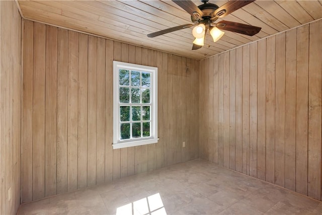 spare room featuring wood ceiling, ceiling fan, and wood walls