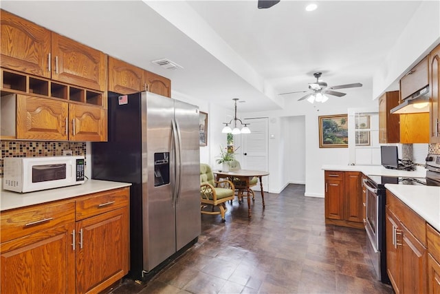 kitchen with pendant lighting, ceiling fan, appliances with stainless steel finishes, and tasteful backsplash