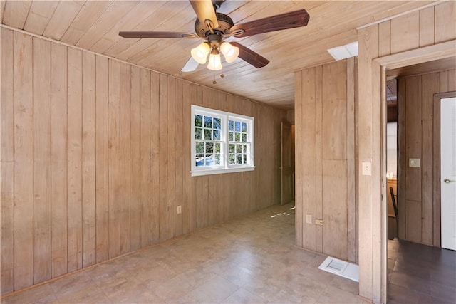 empty room featuring wood ceiling, wooden walls, and ceiling fan