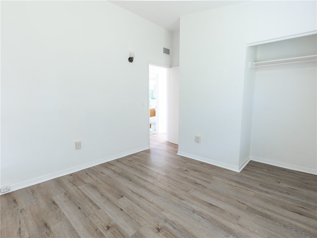 unfurnished bedroom featuring light hardwood / wood-style flooring and a closet