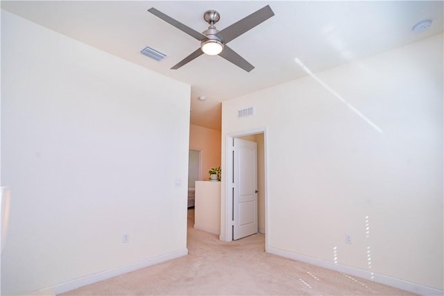 empty room with ceiling fan and light colored carpet