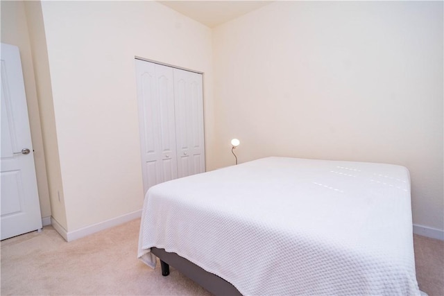 bedroom featuring light carpet and a closet