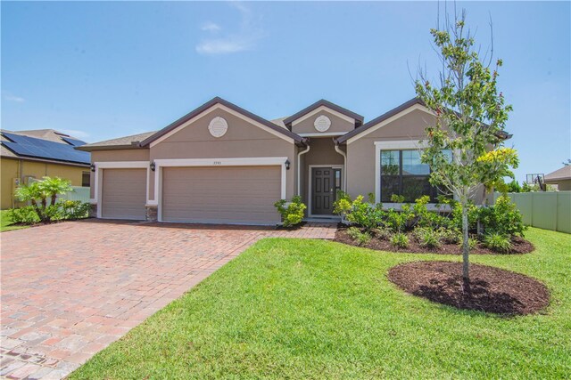 ranch-style home featuring a garage and a front lawn