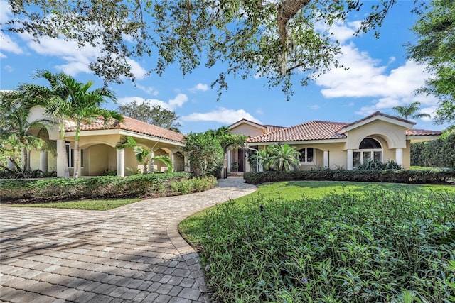 mediterranean / spanish-style house featuring a front lawn