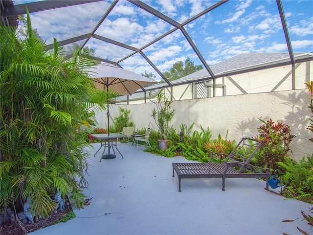 view of patio featuring glass enclosure