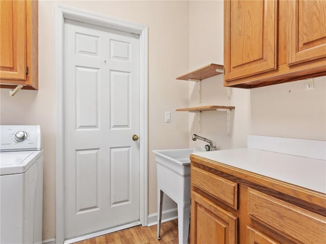 laundry room with cabinets, washer / dryer, and light wood-type flooring