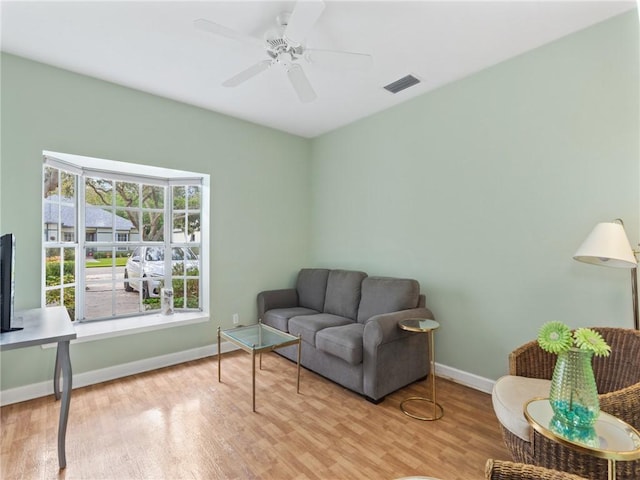 living room with ceiling fan and light hardwood / wood-style flooring