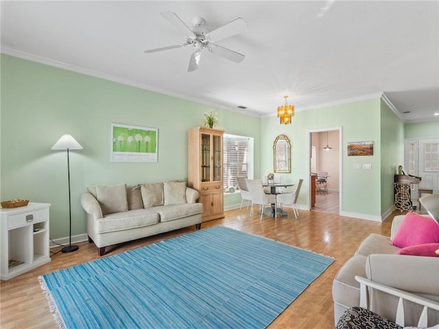 living room featuring ceiling fan with notable chandelier, light wood-type flooring, and ornamental molding