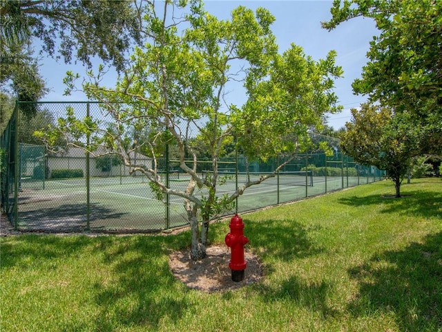 view of tennis court with a lawn