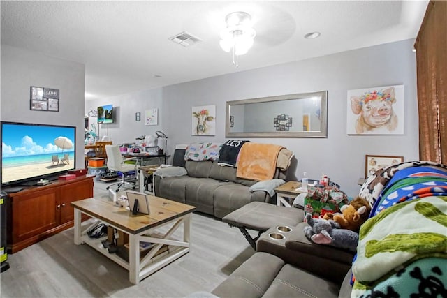 living room with ceiling fan and light hardwood / wood-style floors