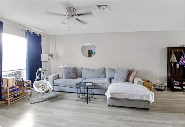 living room featuring light hardwood / wood-style floors and ceiling fan