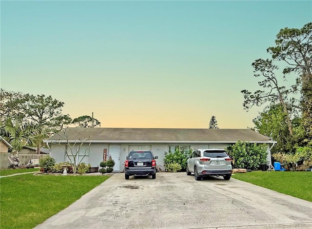 ranch-style house with concrete driveway and a front yard