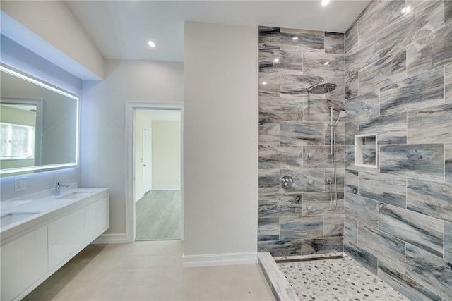 bathroom featuring a tile shower and vanity