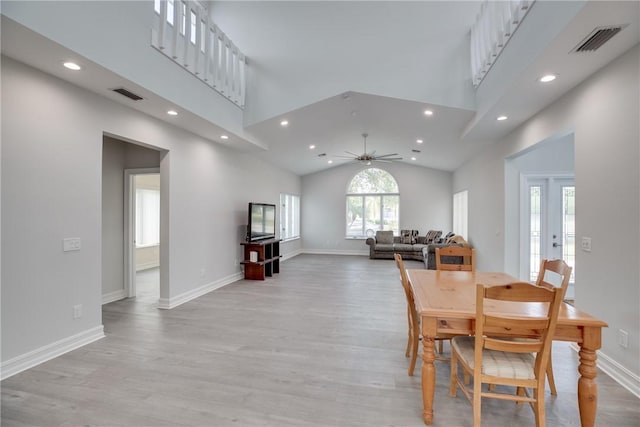 dining area with ceiling fan, high vaulted ceiling, and light hardwood / wood-style flooring