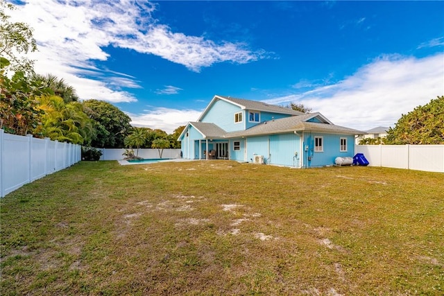 rear view of property featuring a lawn