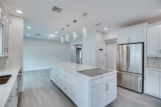 kitchen with backsplash, white cabinetry, appliances with stainless steel finishes, and a kitchen island