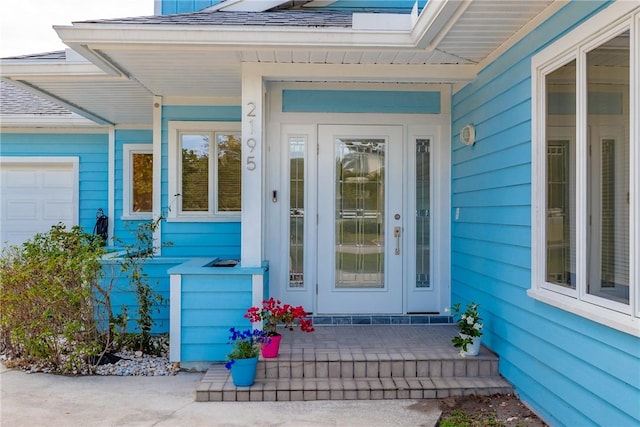 entrance to property with a garage and covered porch