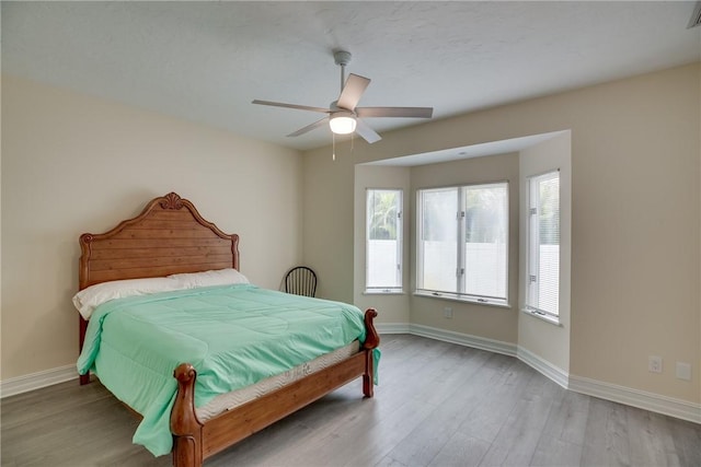 bedroom with ceiling fan and light hardwood / wood-style flooring