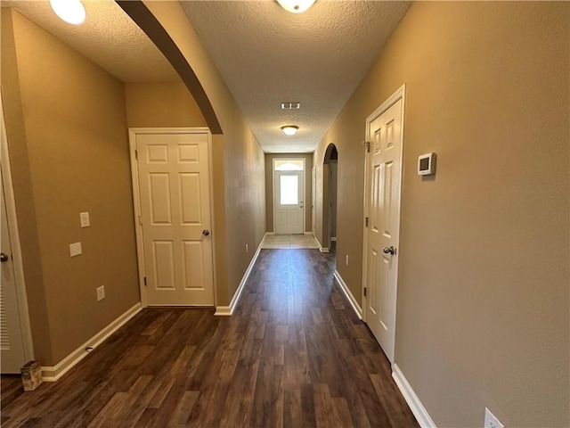 3315 Rockport St SW, Vero Beach, FL 32968 - hall with arched walkways, dark wood-style floors, and a textured ceiling