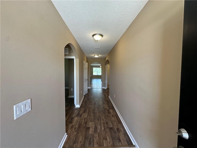 3315 Rockport St SW, Vero Beach, FL 32968 - corridor featuring arched walkways, dark wood-style flooring, and a textured ceiling