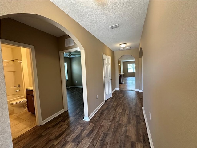 3315 Rockport St SW, Vero Beach, FL 32968 - hallway with dark wood finished floors, arched walkways, and a textured ceiling