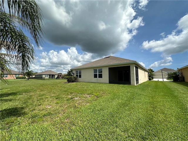 3315 Rockport St SW, Vero Beach, FL 32968 - back of property with stucco siding and a yard