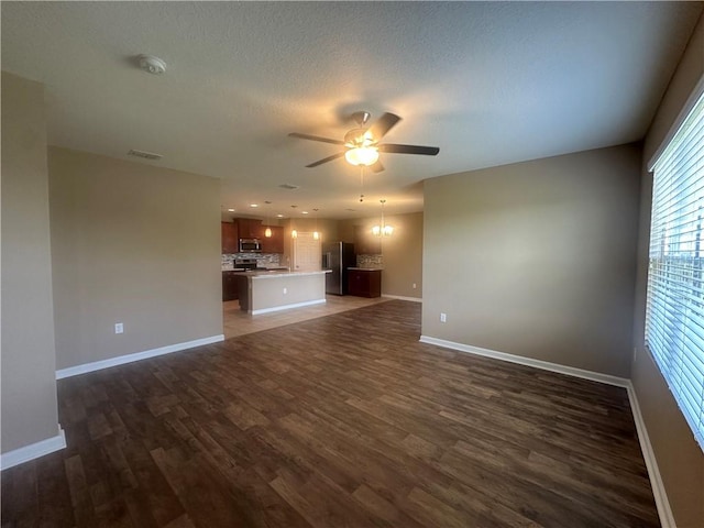 3315 Rockport St SW, Vero Beach, FL 32968 - unfurnished living room featuring a ceiling fan, dark wood finished floors, and a textured ceiling