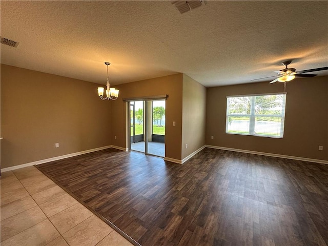 3315 Rockport St SW, Vero Beach, FL 32968 - spare room with healthy amount of natural light, a chandelier, dark wood-style flooring, ceiling fan, and a textured ceiling