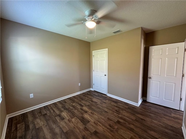 3315 Rockport St SW, Vero Beach, FL 32968 - unfurnished bedroom featuring dark wood-style flooring, a textured ceiling, and a ceiling fan