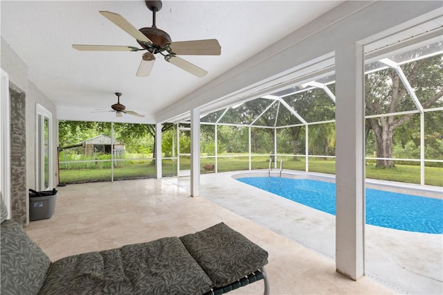 outdoor pool featuring ceiling fan, glass enclosure, and a patio area