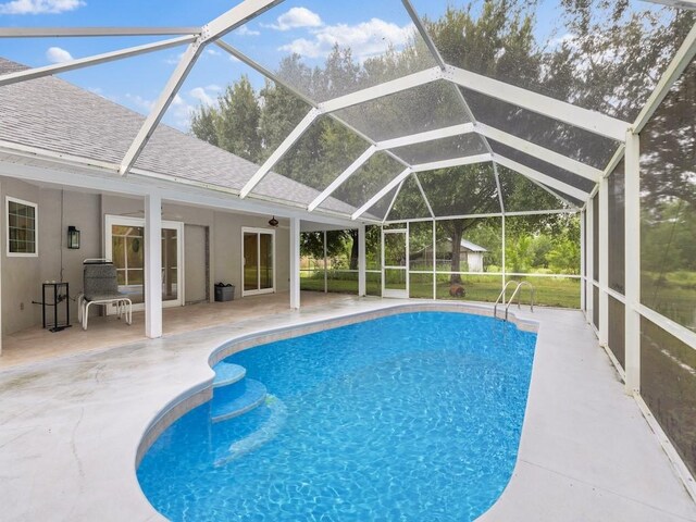 view of pool with a patio, glass enclosure, ceiling fan, and french doors