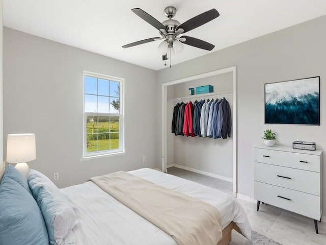 bedroom with ceiling fan, a closet, and baseboards