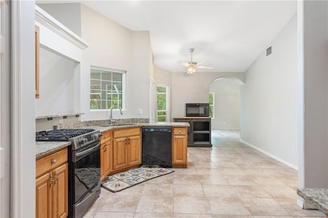 kitchen with light tile patterned flooring, sink, light stone counters, ceiling fan, and black appliances