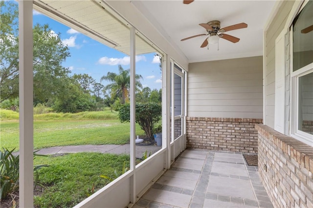 unfurnished sunroom featuring ceiling fan