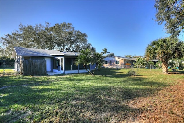 view of yard with a sunroom and fence