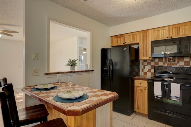 kitchen with tile counters, a textured ceiling, decorative backsplash, a ceiling fan, and black appliances
