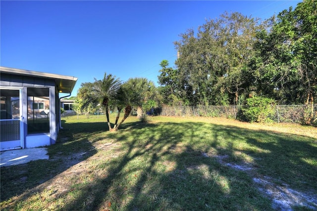 view of yard featuring a sunroom and a fenced backyard