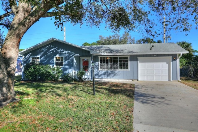 ranch-style house featuring driveway, a garage, and a front yard