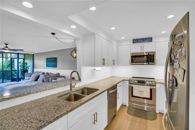 kitchen featuring sink, white cabinets, stainless steel appliances, and light hardwood / wood-style floors