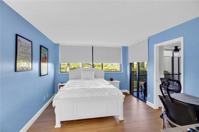 bedroom featuring access to exterior and wood-type flooring