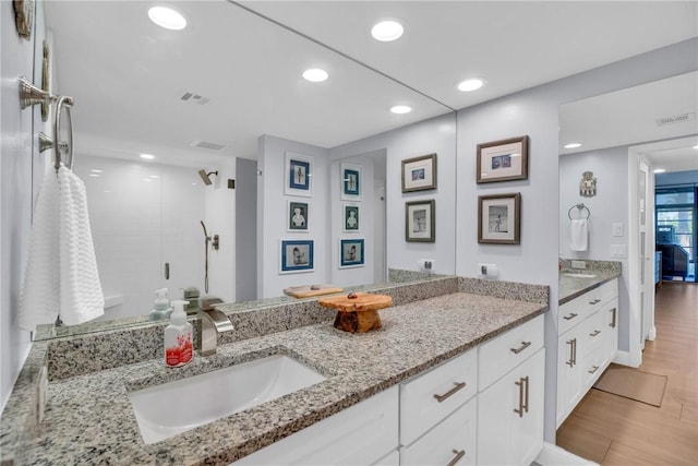 bathroom featuring a shower, vanity, and hardwood / wood-style flooring